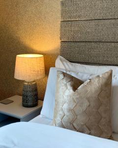 a bed with a lamp and a pillow on a side table at The Stokesay Boutique Townhouse Ludlow in Ludlow