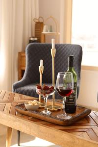 a table with a bottle of wine and two glasses at THHPSOCIETY - Exstacy stays & cafe - Your Romantic & Cozy Getaway - Mountain view , Hot tub , Parking - MUKTESHWAR in Mukteshwar