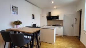 a kitchen with a table and chairs in a room at Schubert's in Bruckneudorf