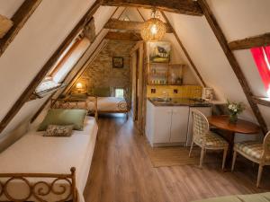 a small attic room with a bed and a kitchen at Château de Taussac in Taussac