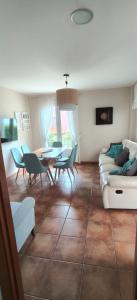 a living room with a couch and a table and chairs at Xanela da Ría in Quenje