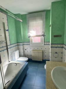 a bathroom with a tub and a toilet and a sink at Xanela da Ría in Quenje +9 photos