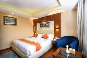 a hotel room with a bed and a blue chair at Kumari Boutique Hotel in Kathmandu +76 photos