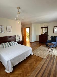 a bedroom with a large bed and a living room at Xanela da Ría in Quenje