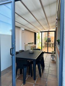 a dining room with a black table and chairs at Xanela da Ría in Quenje