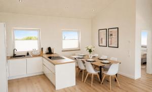 a kitchen and dining room with a table and chairs at Ferienhaus Elbdeichblick 1 in Haselau