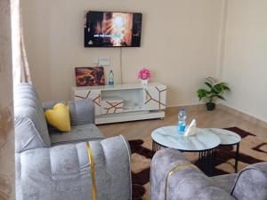 a living room with two couches and a table at EMIC Suites in Nyahururu