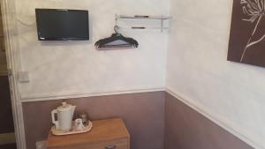 a room with a table and a tv on a wall at Hornby House Hotel in Blackpool