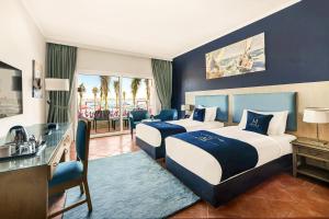 a hotel room with two beds and a balcony at M Hotels at Porto Marina in El Alamein +109 photos