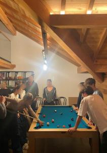 a group of people standing around a pool table at Chalet Chante Guisane in Saint-Chaffrey
