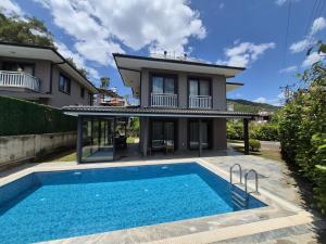 a house with a swimming pool in front of a house at Villa Kaya Maris Göcek in Fethiye