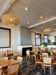 a dining room with tables and chairs and chandeliers at Pier Hotel Port Lincoln in Port Lincoln