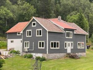 a black house with a red roof in a yard at Nordgården in Handeland