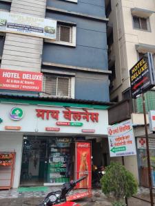 a building with a hotel deliverer in front of it at Hotel Deluxe in Hinjewadi