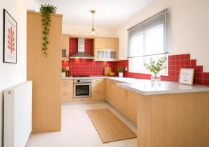 a kitchen with red tiles on the wall at Holiday Lefkas Moonlight Luxury Appartments in Nikiana