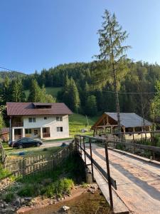 a house with a bridge next to a road at Apuseni Escape in Gârda de Sus