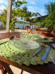 a table with a plate and a glass cup on it at Chalé Brisa da Lagoa in Icaraí
