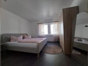 a bedroom with a bed and a mirror and a sink at FeWo MaiFlo in Briedern