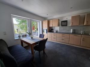 a kitchen with a table and chairs and a window at FeWo MaiFlo in Briedern