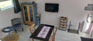a room with a table and a chair and a television at Le gîte des Allains in Sainte-Suzanne-en-Bauptois