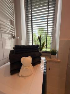 a teddy bear sitting on top of a table with towels at Apartament Modrzewia in Elblag