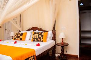 a bedroom with a bed with orange and yellow pillows at Charming Penthouse -Holidays Houses in Malindi