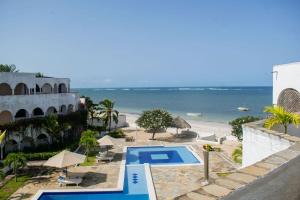 a resort with a swimming pool and a beach at Charming Penthouse -Holidays Houses in Malindi