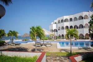 a resort with a swimming pool and palm trees at Charming Penthouse -Holidays Houses in Malindi