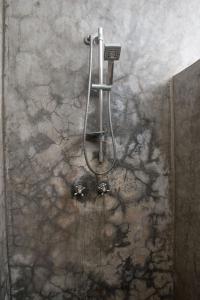 a shower in a bathroom with a stone wall at Charming Penthouse -Holidays Houses in Malindi +37 photos