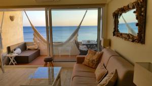 - un salon avec un canapé et une vue sur l'océan dans l'établissement Akisol Sesimbra Beach II, à Sesimbra
