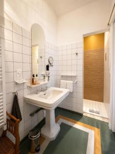 a white bathroom with a sink and a shower at La Maison au toit vert in Espalion