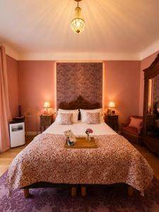 a bedroom with a large bed with a table on it at La Maison au toit vert in Espalion