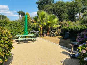a green picnic table and chairs in a garden at Maison de caractère datant de 1739 in Quistinic