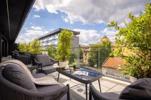 a patio with chairs and a table on a balcony at PLATINUM hotel & spa in Sarajevo
