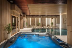 a large pool with a blue tub in a hotel room at PLATINUM hotel & spa in Sarajevo