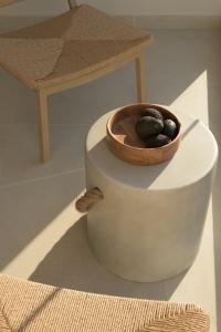 a bowl of rocks on a table with a stool at Fata Morgana Studios & Apartments in Frangokastello