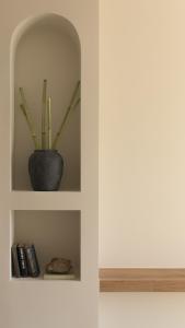 a shelf with a plant in a vase on it at Fata Morgana Studios & Apartments in Frangokastello