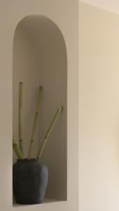 a black vase with a plant in a room at Fata Morgana Studios & Apartments in Frangokastello