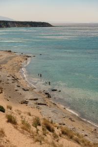 a group of people swimming in the water on a beach at Fata Morgana Studios & Apartments in Frangokastello