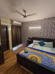 a bedroom with a bed and a ceiling fan at 2BHK 65TV,FullyAC,family,Unmarried Couple,WFO Friendly peacefull place in Noida +7 photos
