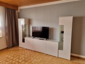 a living room with a flat screen tv on a white cabinet at Tinas Ferienwohnung in Kröv