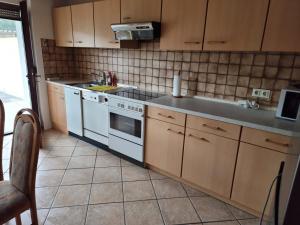 a kitchen with a white stove and a sink at Tinas Ferienwohnung in Kröv