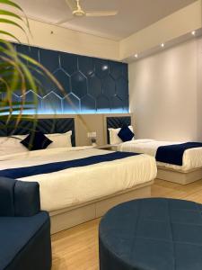 a bedroom with two beds and a blue wall at The Origin Suites opposite Hyatt Dlf my pad Lucknow in Lucknow