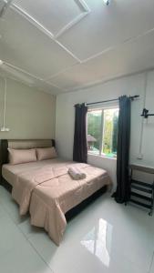 a bedroom with a large bed with a window at Durian Chalet in Kuala Tahan