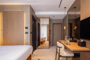 a bedroom with a bed and a desk with chairs at PLATINUM hotel & spa in Sarajevo