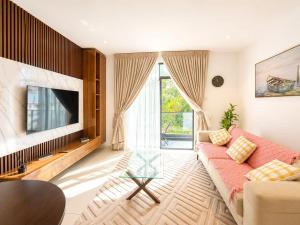 a living room with a couch and a tv at EMBASSY - Sky Suites in Accra