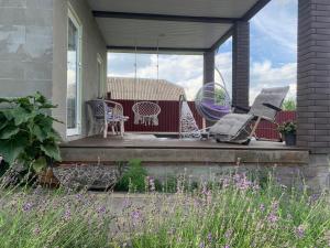 a porch with chairs and tables on a house at AmurRelaxCreative in Khmelnytskyi