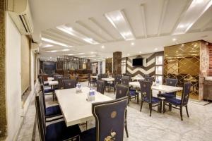 a restaurant with tables and chairs and a bar at Hotel Almati Inn Near IGI Delhi Airport - With Free Airport Pickup in New Delhi