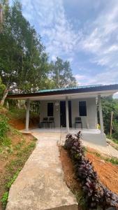 a small white house with a pathway leading to it at Durian Chalet in Kuala Tahan