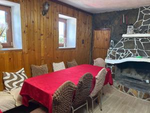 a dining room with a table and a stone fireplace at Къща за гости Изгрев in Trigrad +44 photos